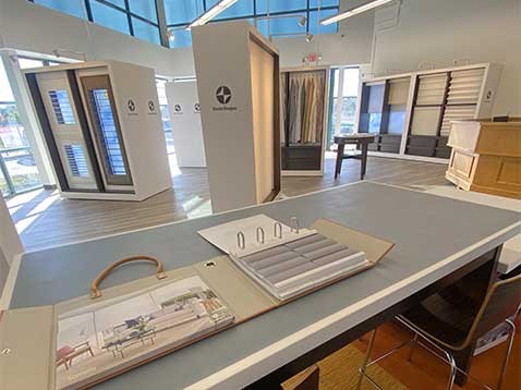 Store interior showing several different window covering displays, and a desk with more samples
