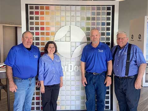 Four dealership staff standing by a Hunter Douglas display