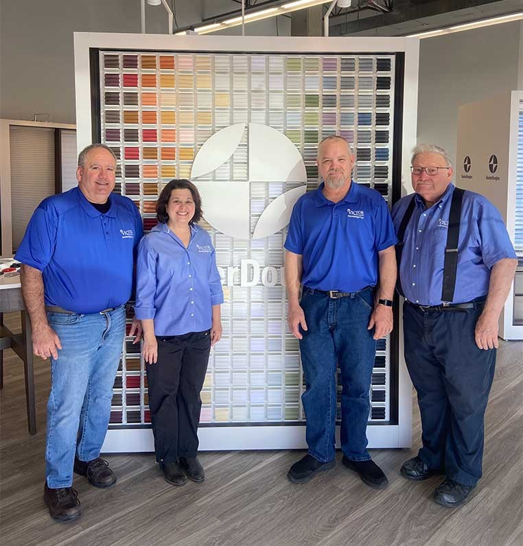 Four dealership staff standing by a Hunter Douglas display